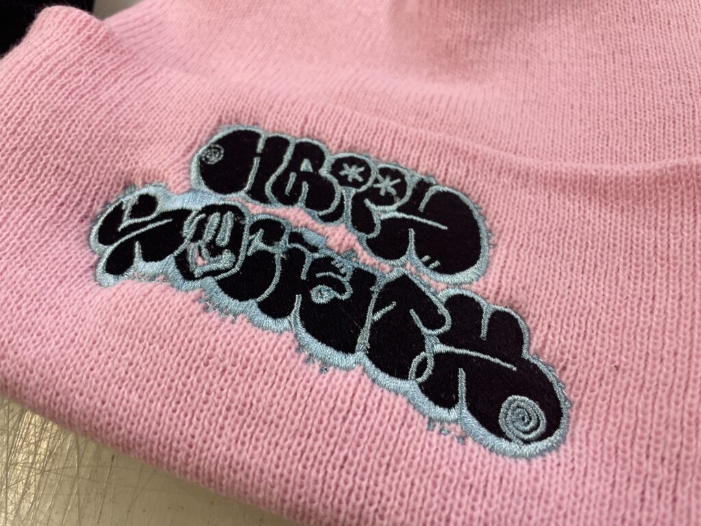 Close-up of a cuffed beanie with embroidered band logo