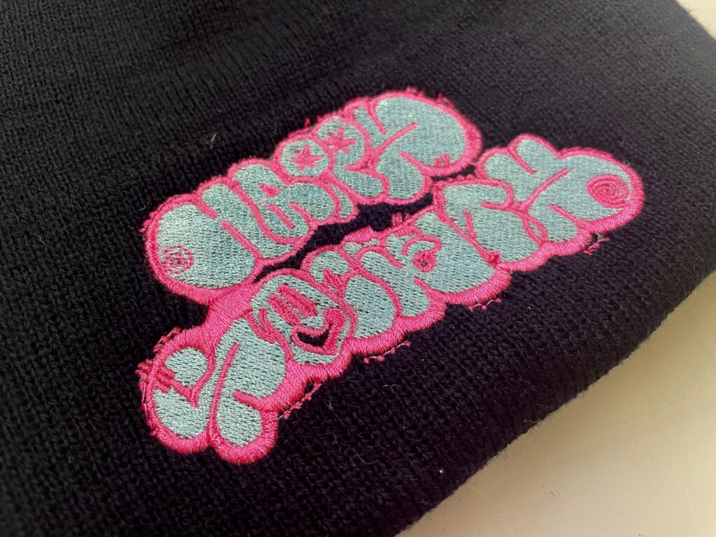 Close-up of a cuffed beanie with embroidered band logo
