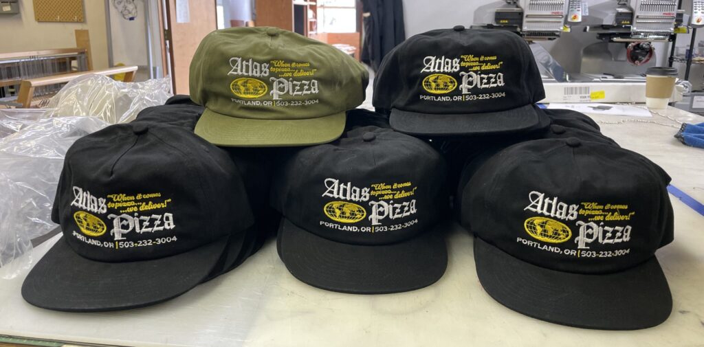 Stack of custom embroidered hats for small business in Portland